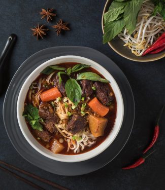 Mi bo kho in a white bowl on black background from above