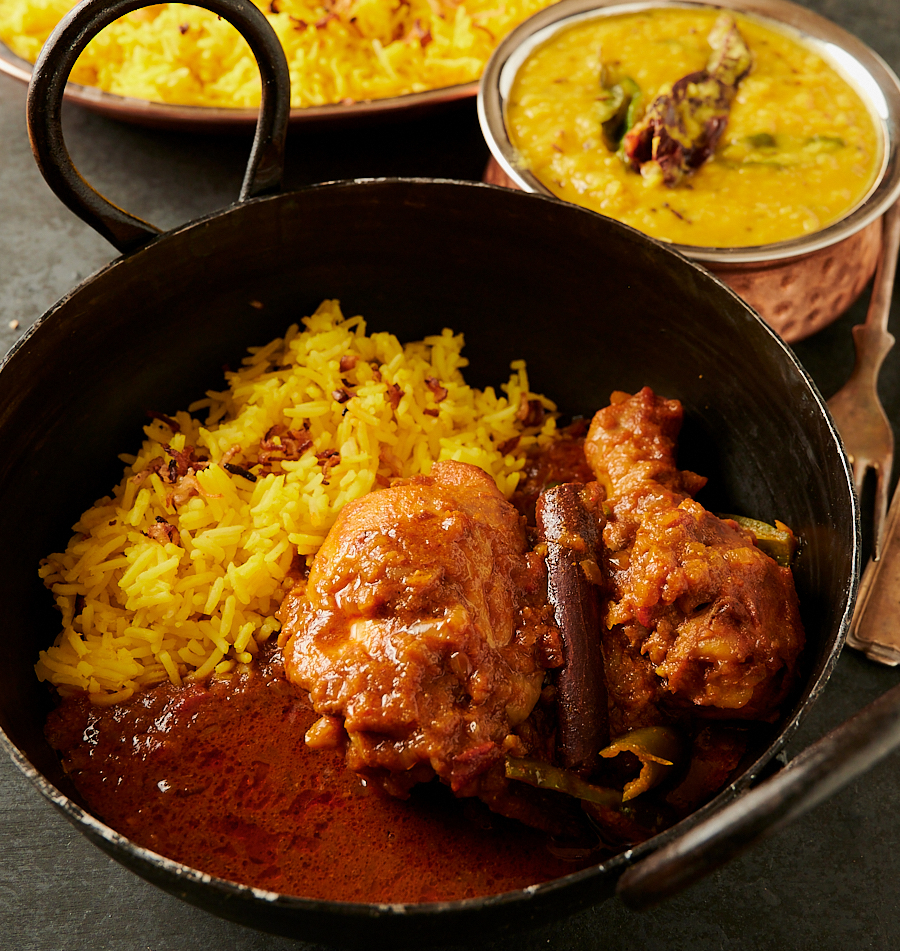 Bowl of simple chicken curry with rice and gravy from the front.