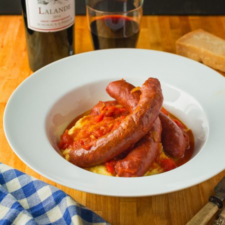 Upscale sausage with peppers served with parmesan polenta.