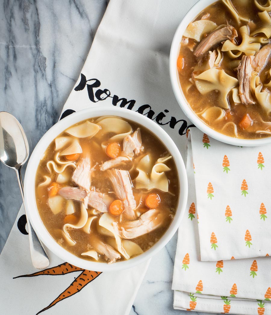 Turkey noodle soup in a white bowl from above.