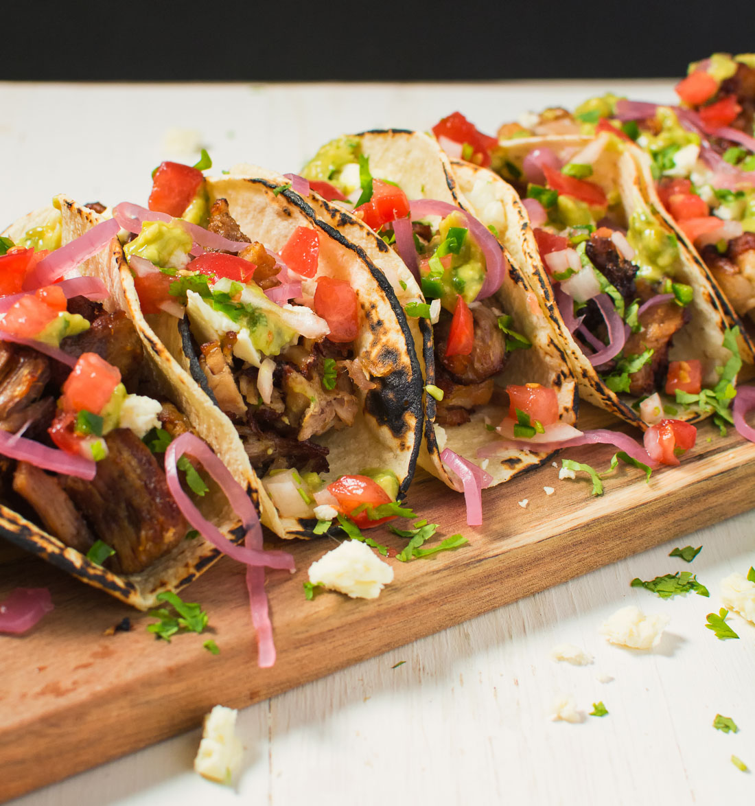 Loaded carnitas tacos with queso, pico, pickled onions and avocado tomatillo salsa.