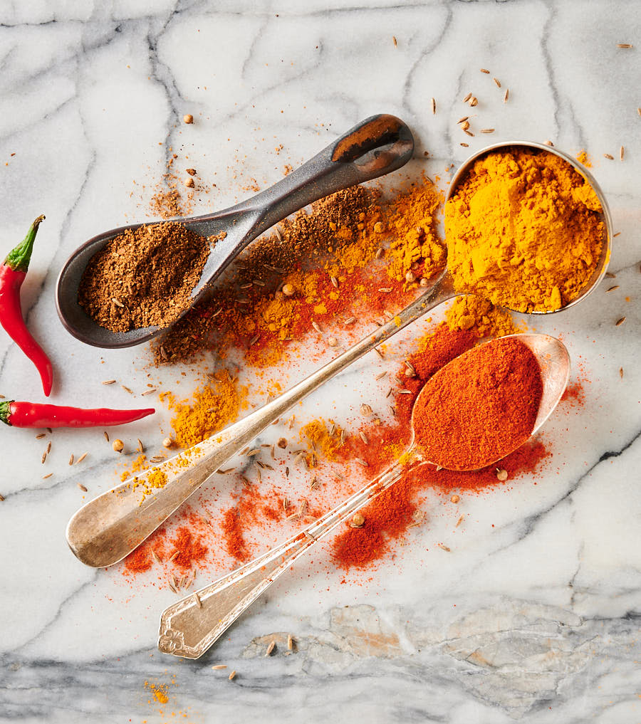 Spoons filled with turmeric, garam masala and Kashmiri chili powder.