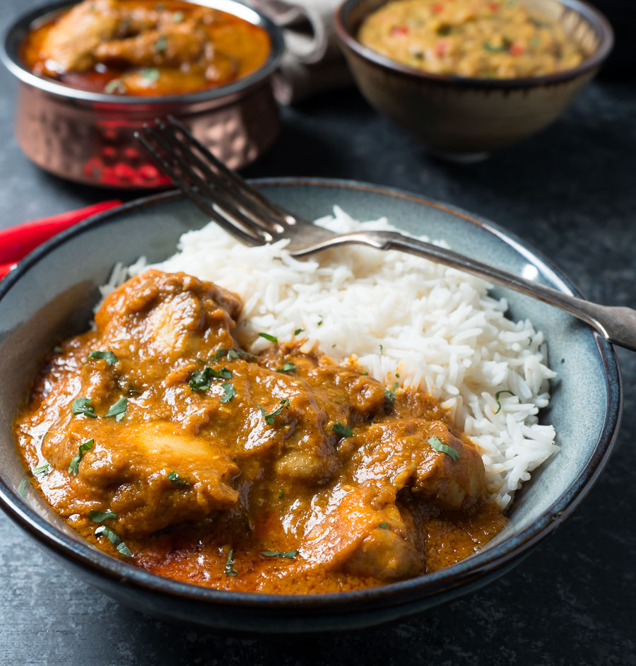 Bowl of chicken madras with rice from the front.