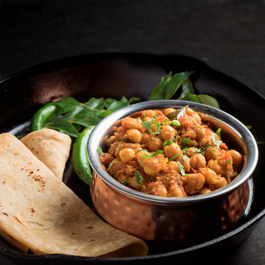 Chana masala in a copper bowl from the front.