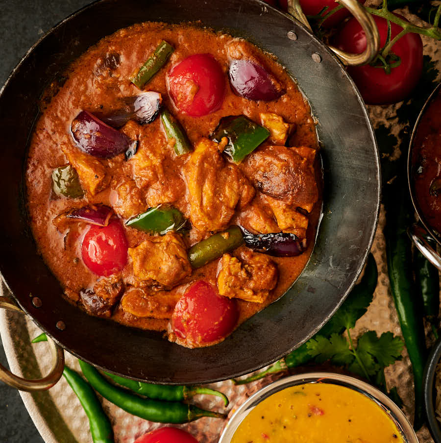 Indian restaurant chicken jalfrezi in a karai from above.