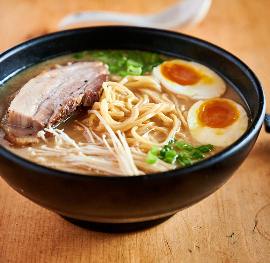 Tonkotsu ramen with egg, pork belly, enoki mushroom and green onion garnish