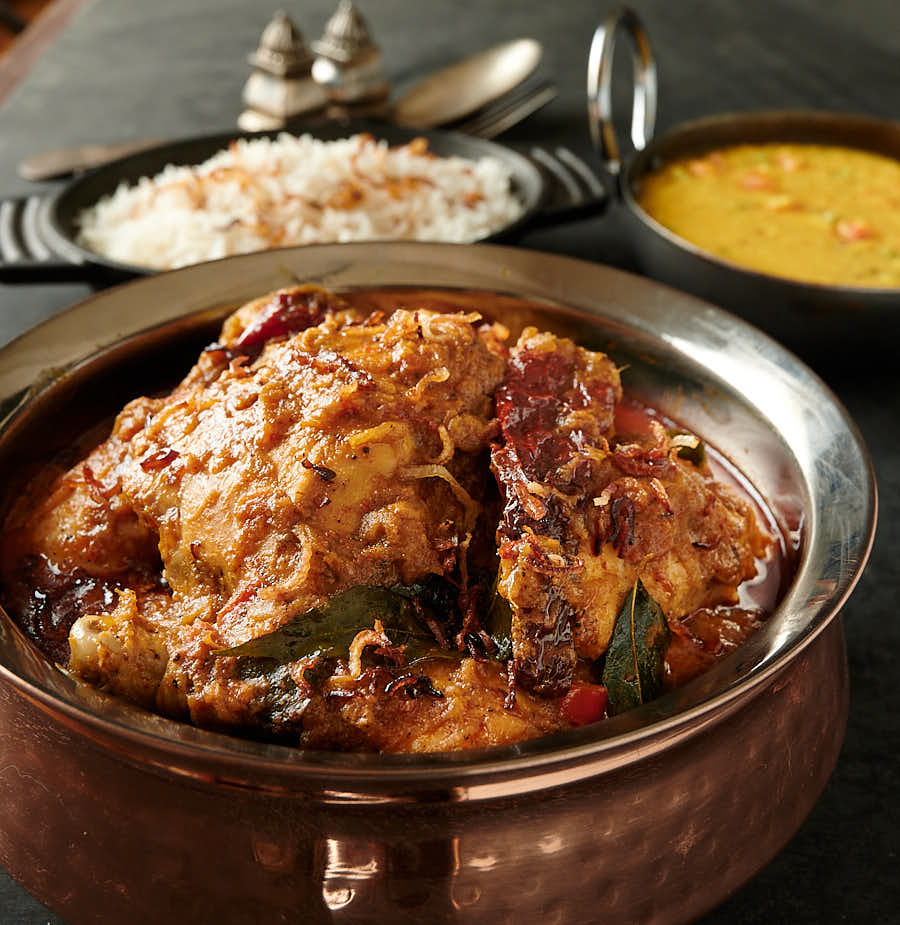 Chettinad chicken curry in an Indian hammered copper bowl from the front.