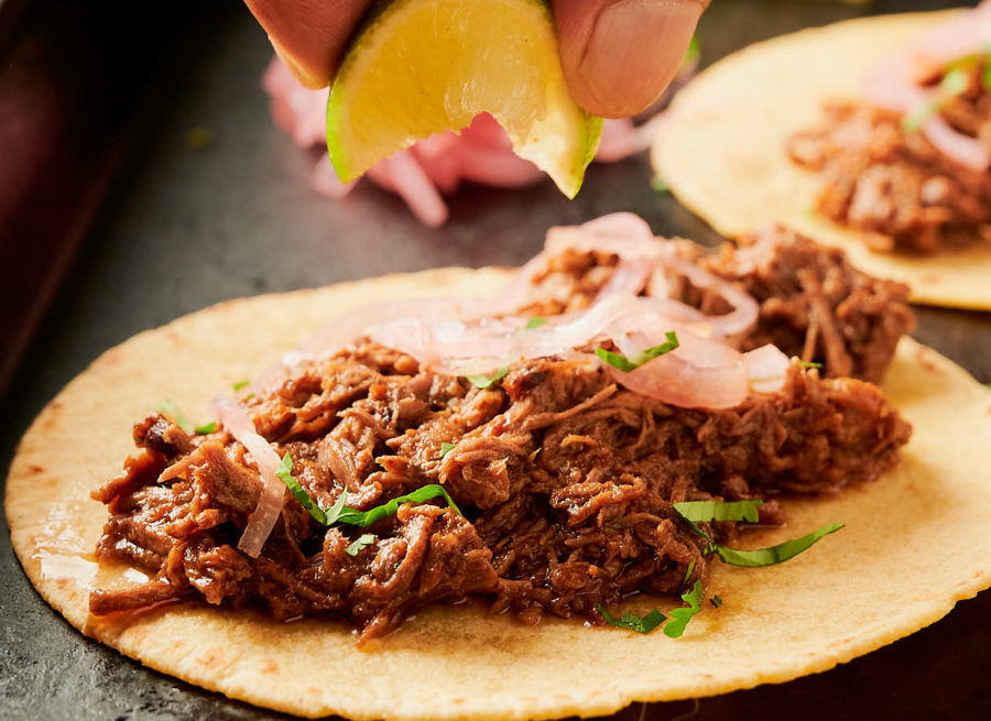 Squeezing lime over beef barbacoa taco