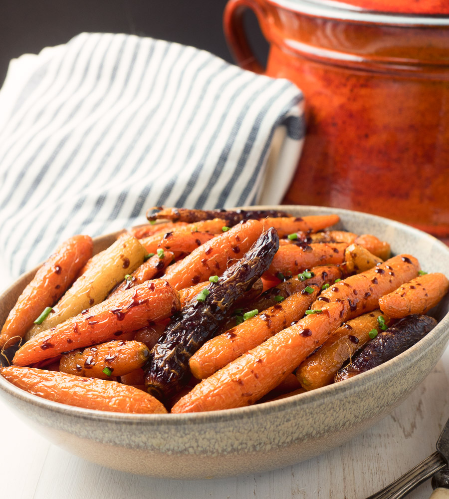 Balsamic roasted carrots in a clay bowl.