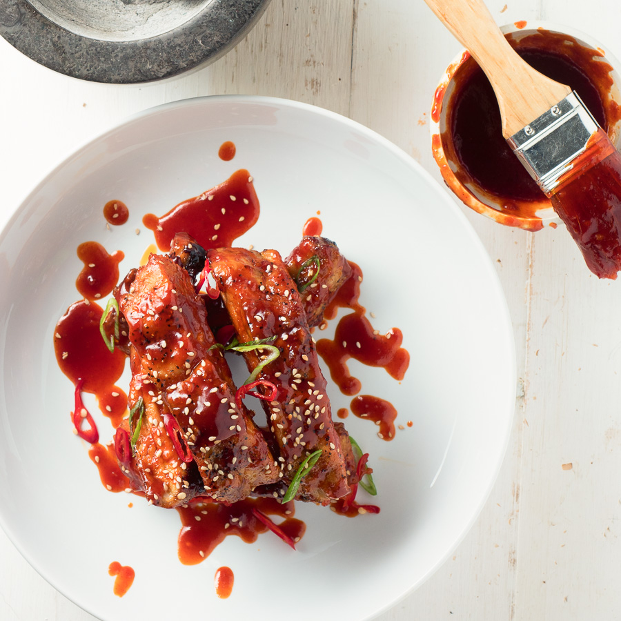 Individual sticky Korean pork ribs with sesame seeds from above.