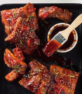 Racks of sticky Korean pork ribs with dipping sauce.