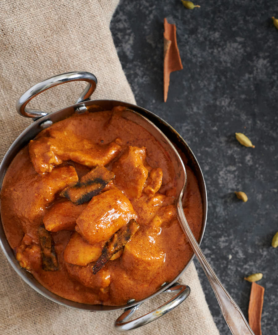 Shahi chicken korma in a serving dish with spoon from above.