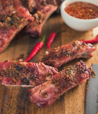 Thai ribs on cutting board with knife