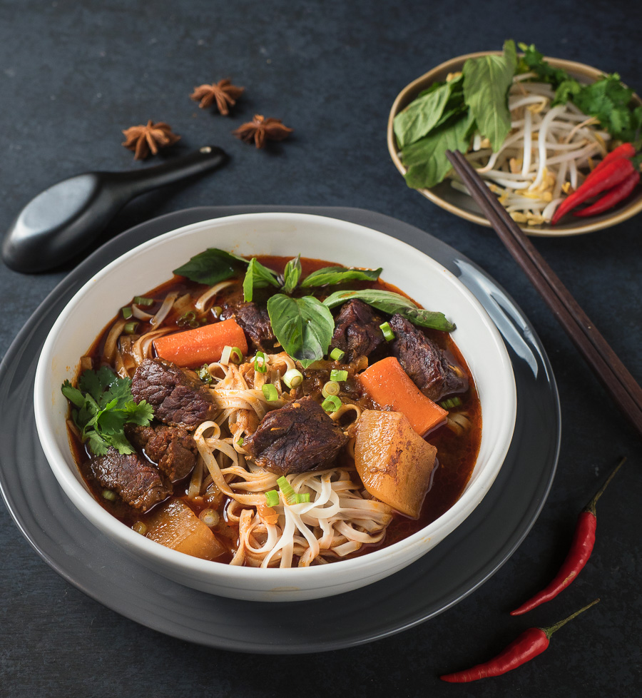 Bo kho in a white bowl on black background from the front