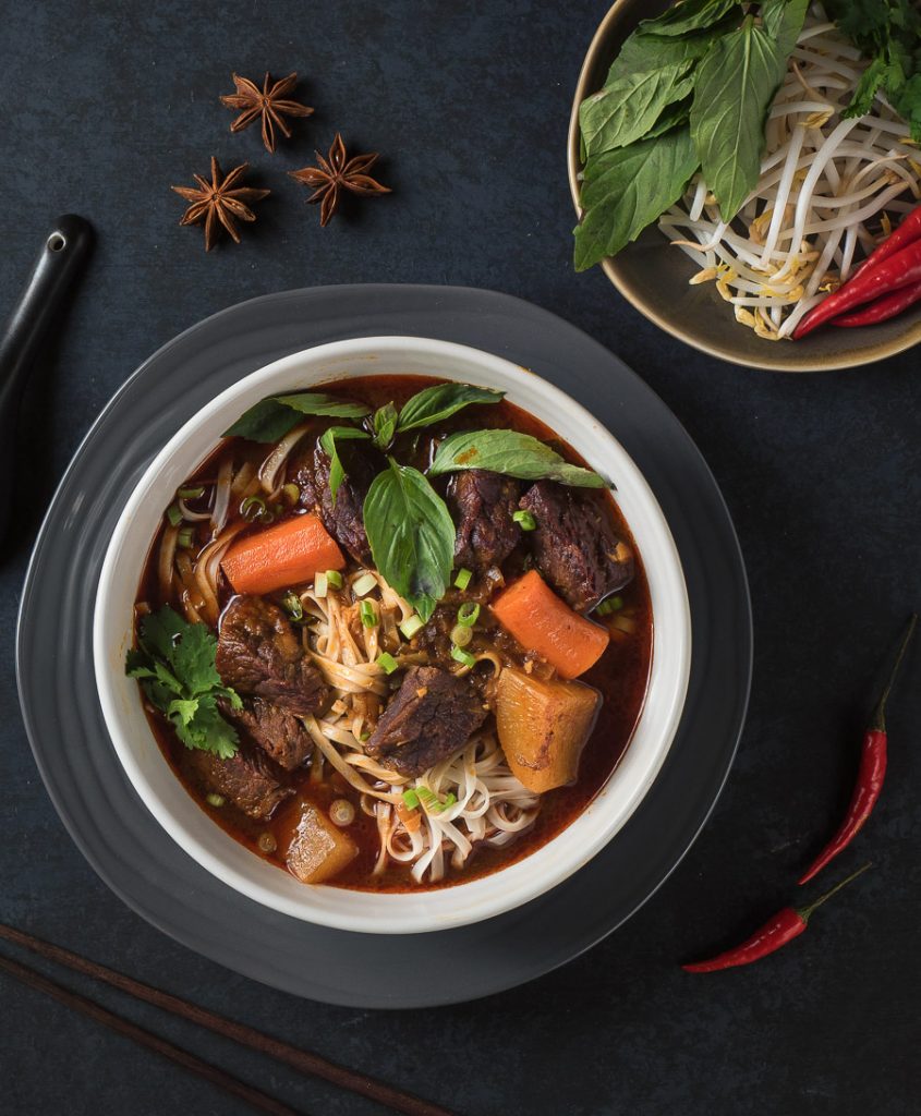 Bo kho in a white bowl on black background from above