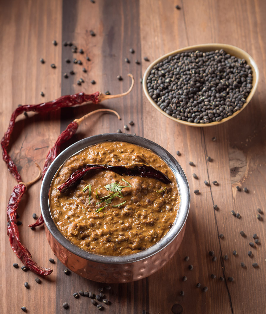 Punjabi dal makhani in a small copper pot garnished with a red chili.