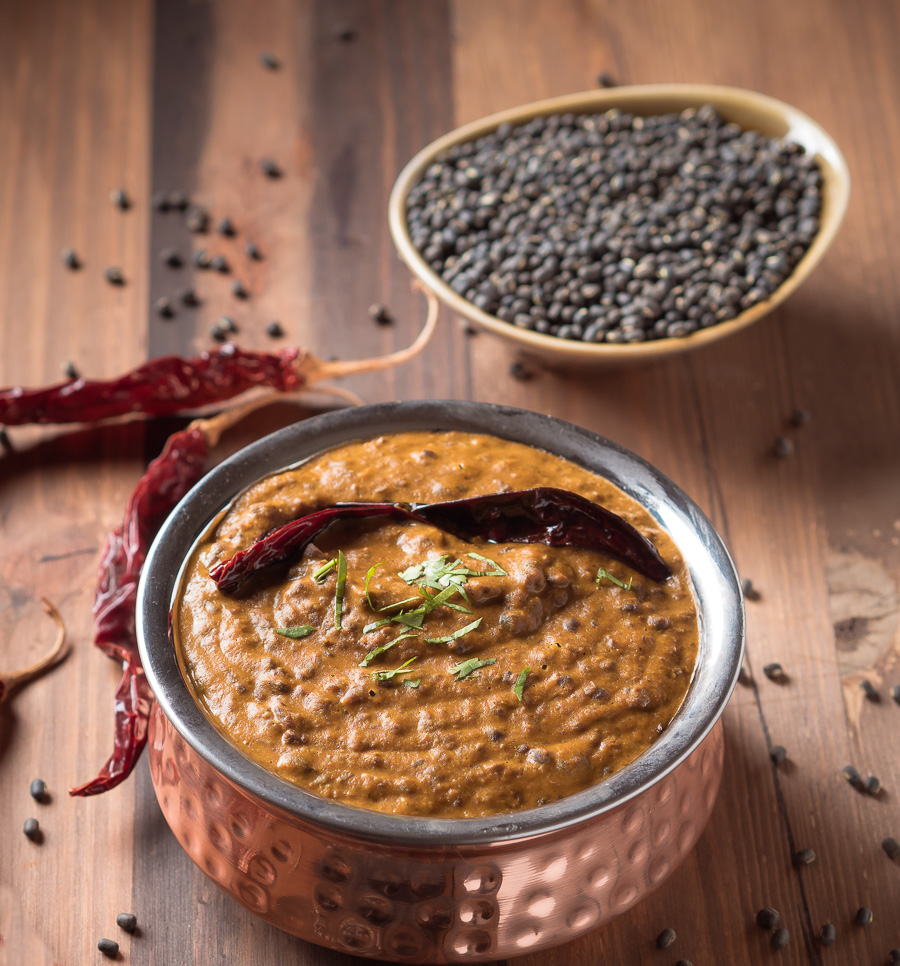 Punjabi dal makhani in a small copper pot garnished with a red chili.