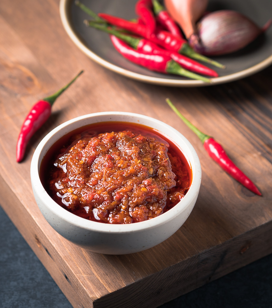 Vietnamese sate sauce in a white bowl with red chilies.