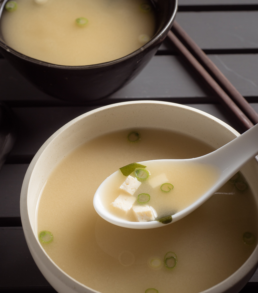 Japanese miso soup in a white bowl with spoon.