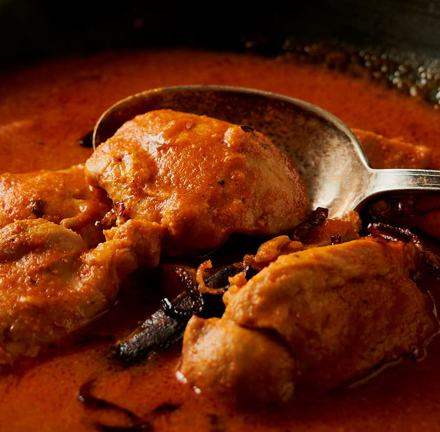 Closeup of chicken madras in a spoon