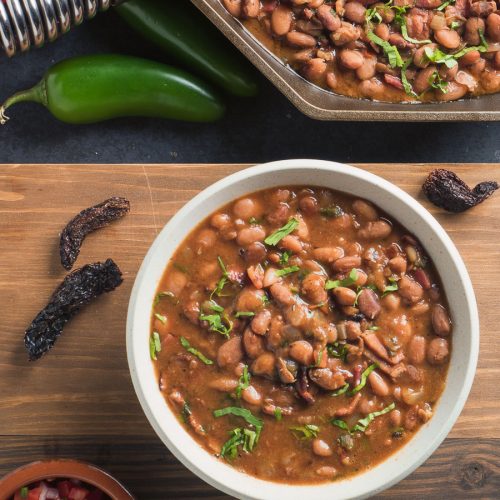 Mexican charro beans in a white bowl. View from above.