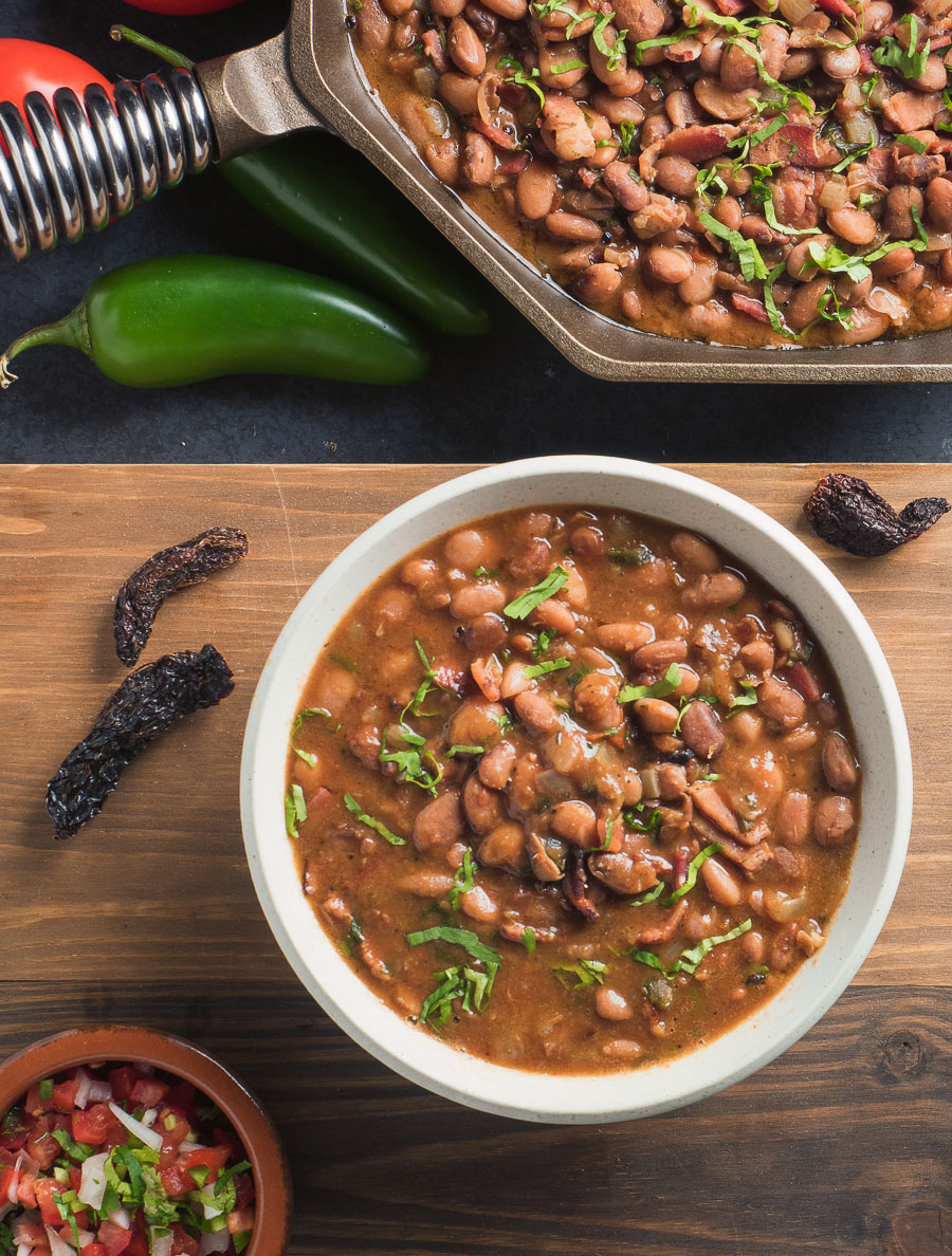 Mexican charro beans in a white bowl. View from above.