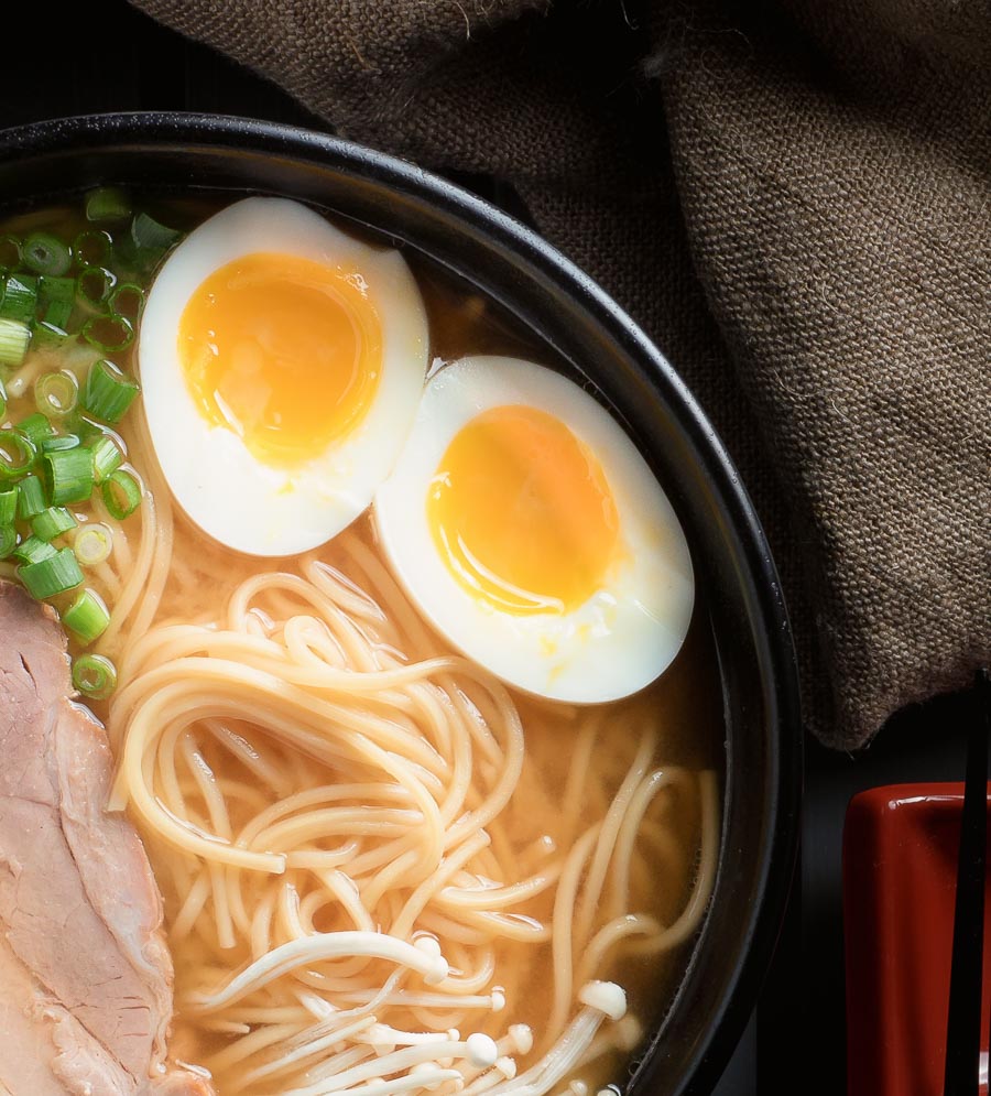 Close up of medium boiled eggs in miso ramen bowl.