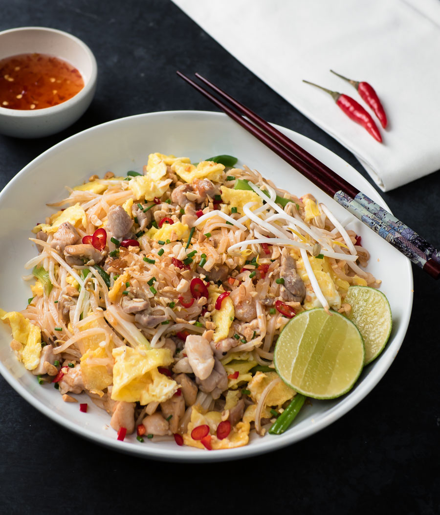 Chicken pad thai in a white bowl from the front.