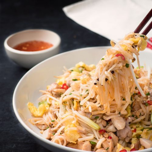 Chicken pad thai mouthful with chopsticks.