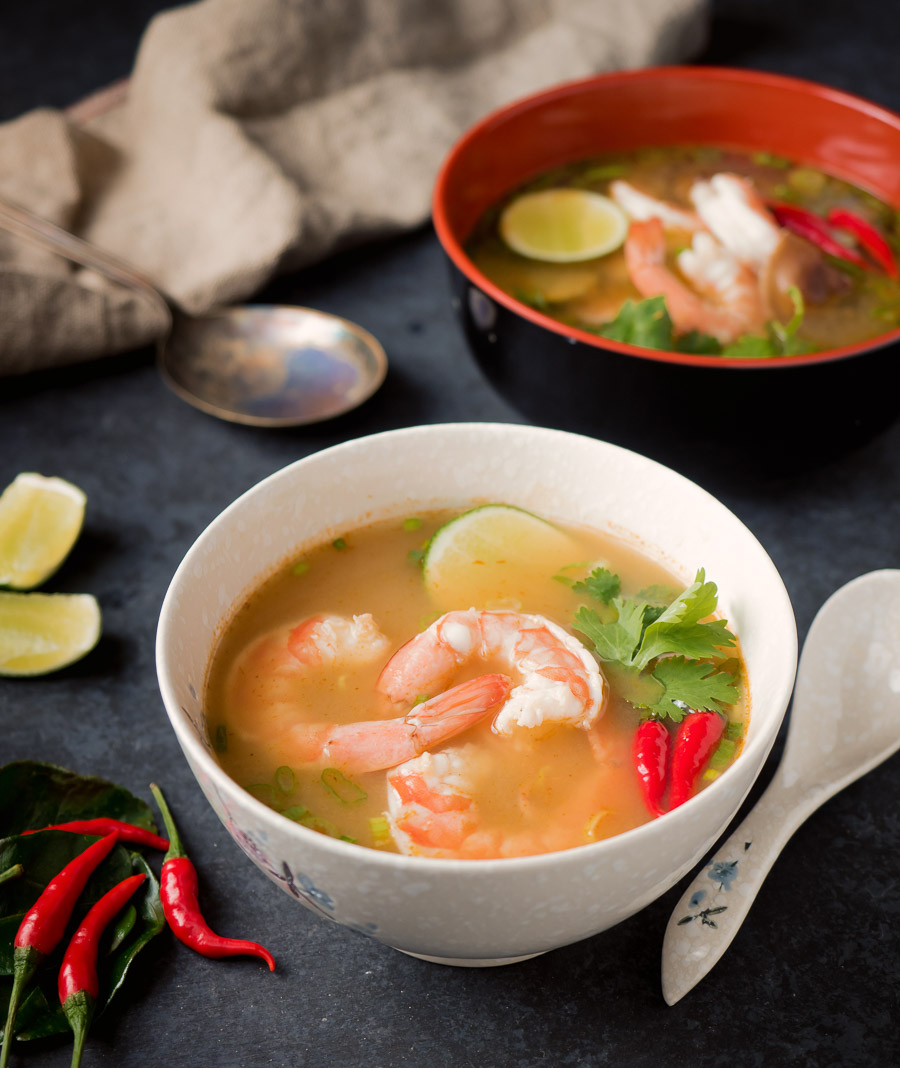 Tom yum soup in a white bowl.