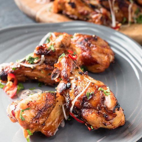 Asian grilled chicken wings on a plate.