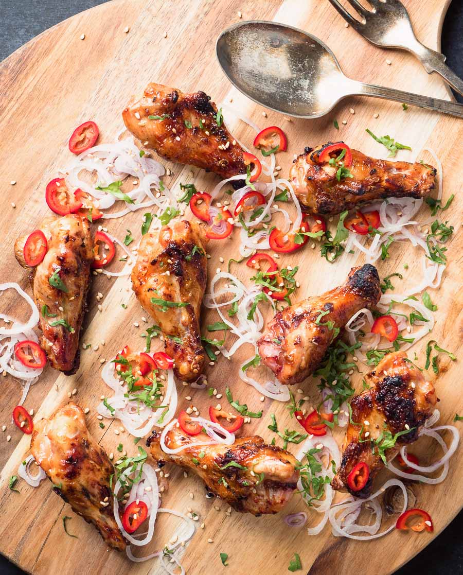 Asian grilled chicken wings on a cutting board from above.