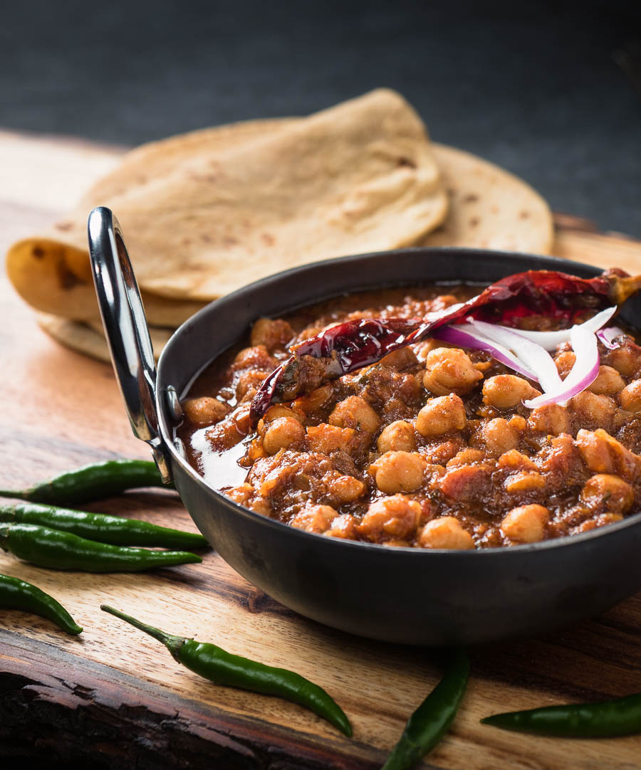 Punjabi chole masala in an Indian iron dish from the front.