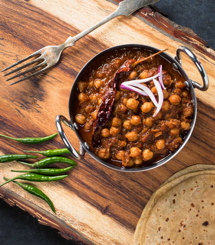 Punjabi chole masala in a iron bowl from above.