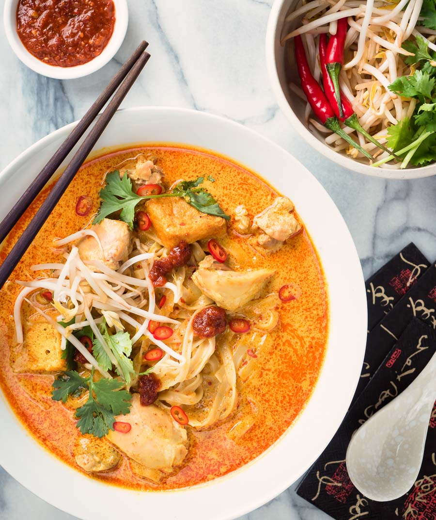 Laksa coconut curry soup from above - garnished with cilantro, red chilies and bean sprouts.