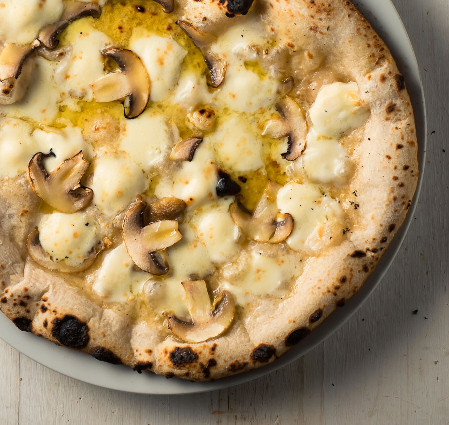 Mushroom, mozzarella and olive oil Neapolitan pizza from above.