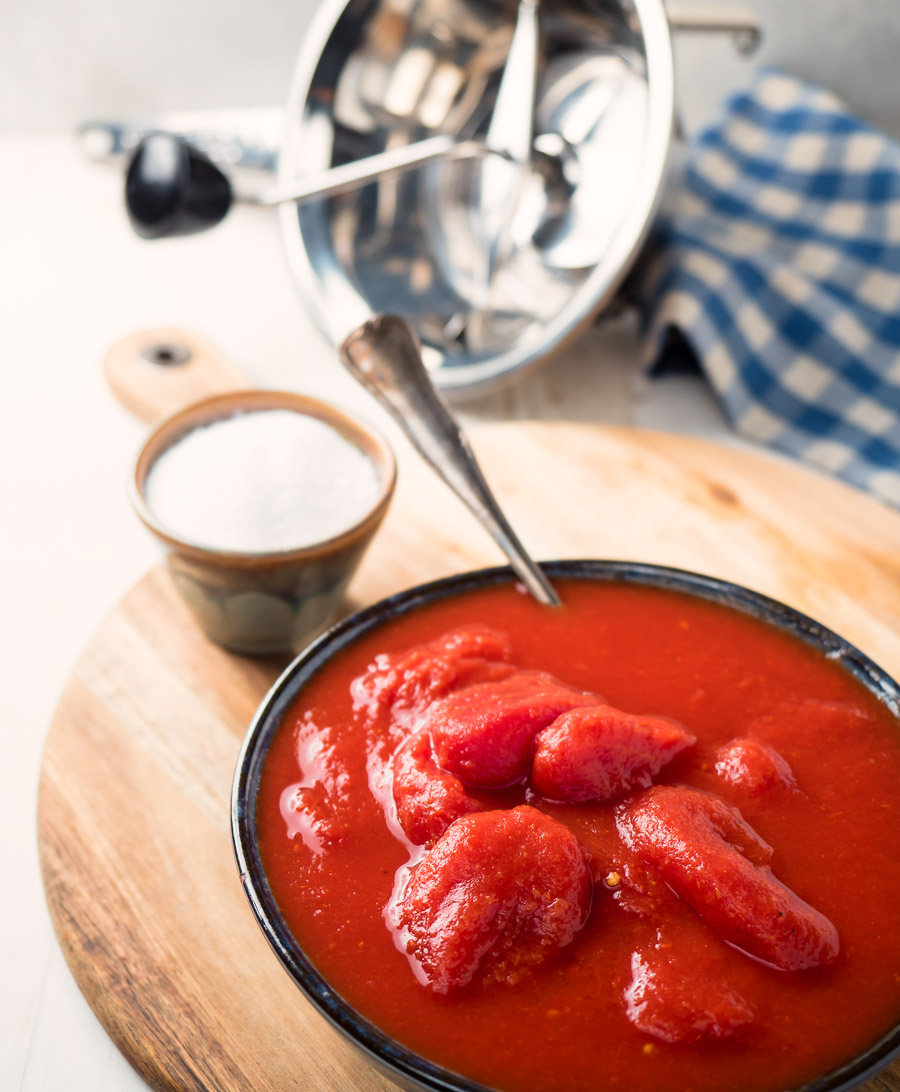 San Marzano tomatoes and salt on a cutting board.