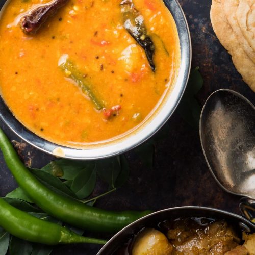 South Indian sambar in a metal bowl from above.