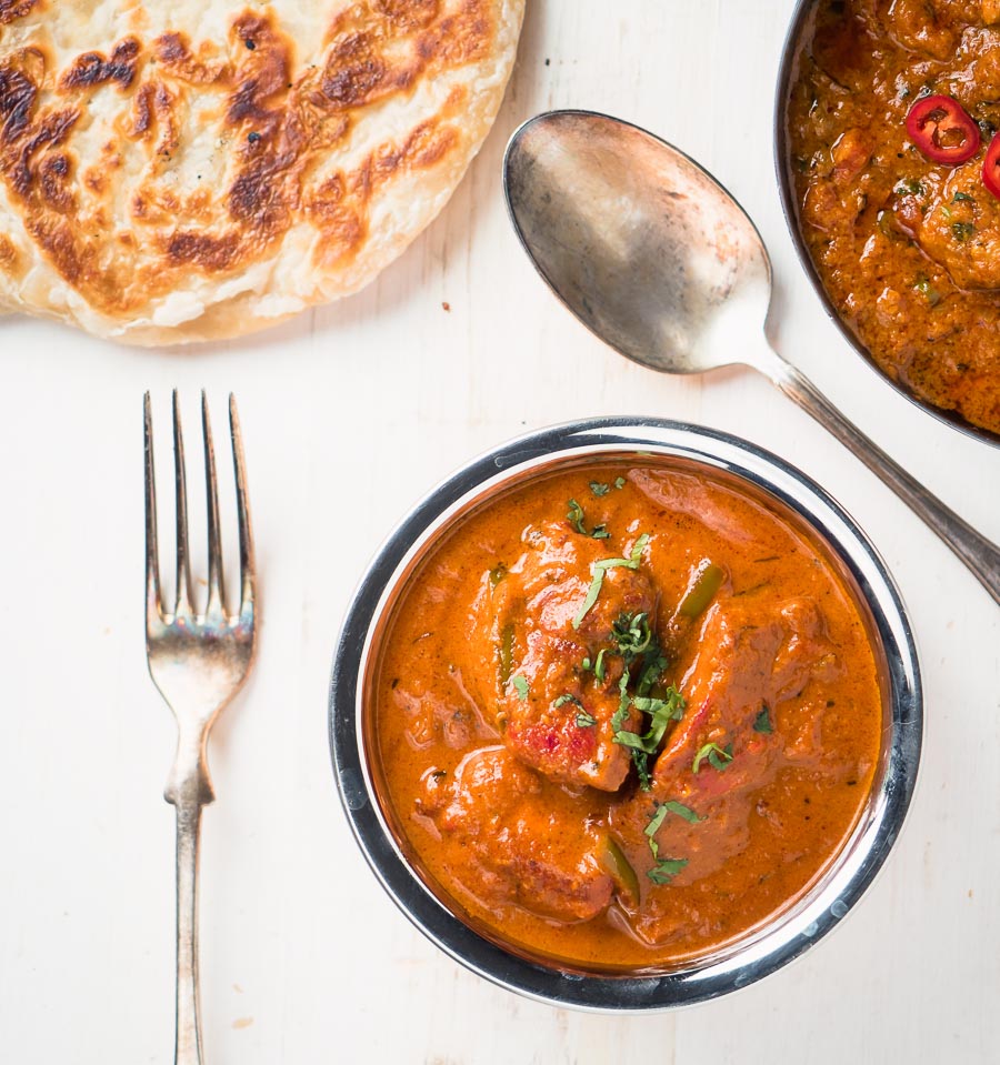 Restaurant butter chicken in bowl from above.