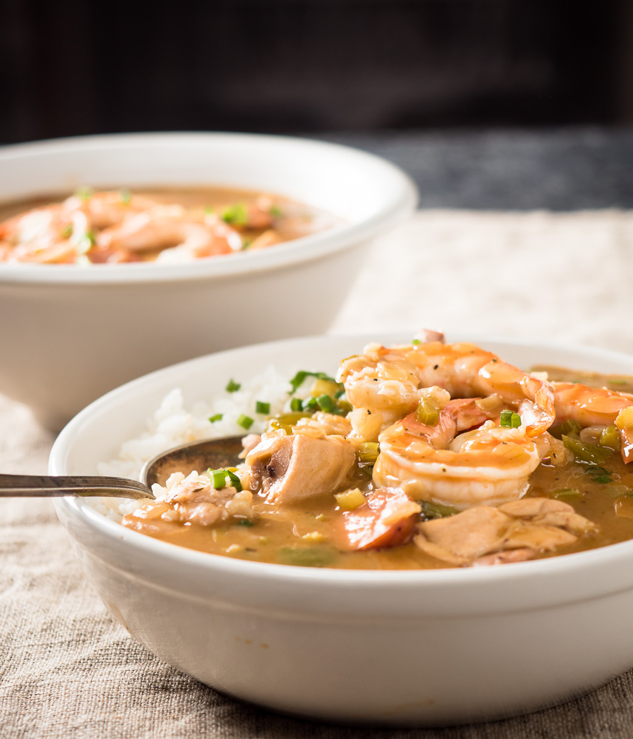 Spoon in a bowl of gumbo with chicken and sausage