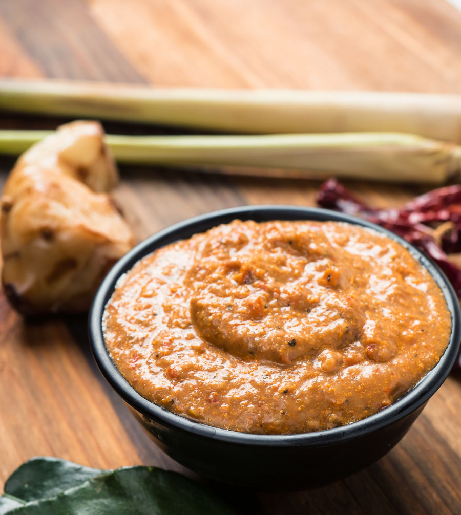 Panang curry paste in a bowl with lemongrass stalks and galangal.