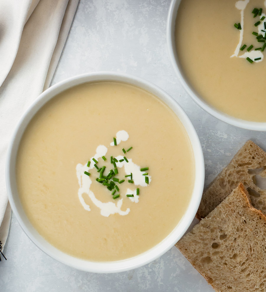 Potato leek soup garnished with cream drizzle and chives - from above.