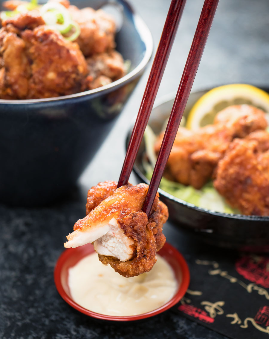 Karaage chicken bite held in chopsticks.