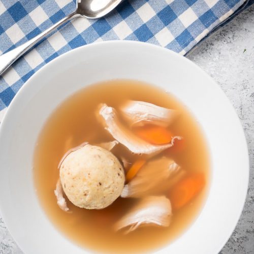Matzo ball soup in a bowl from above.