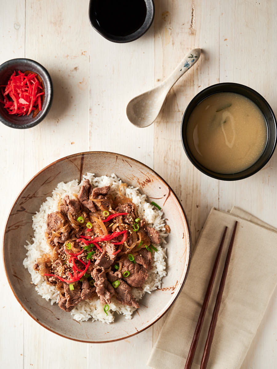 Gyudon, rice and miso soup on a table from above.