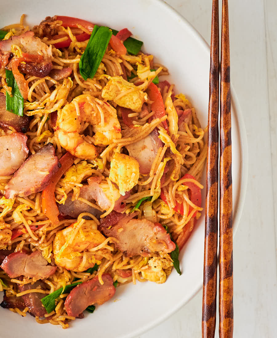 Singapore noodles in a bowl with chopsticks from above