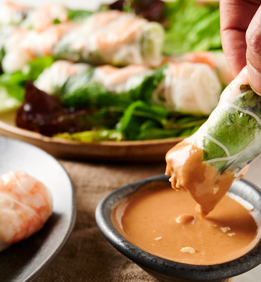 Dipping a Vietnamese spring roll into peanut sauce.