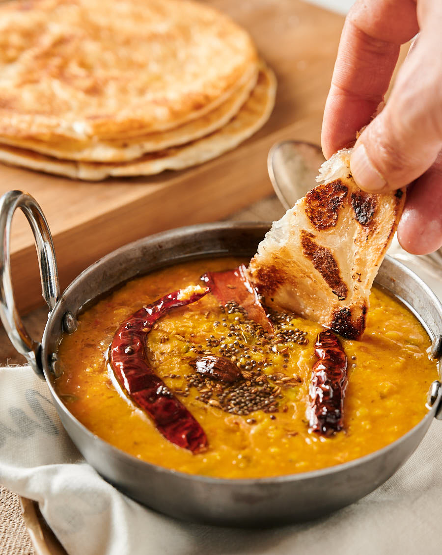 Dipping paratha into dal tadka.