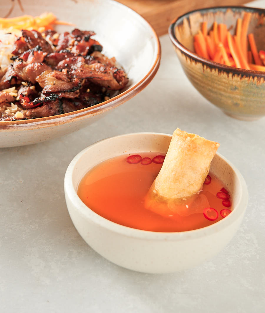 Vietnamese fried spring roll in a bowl of nuoc cham