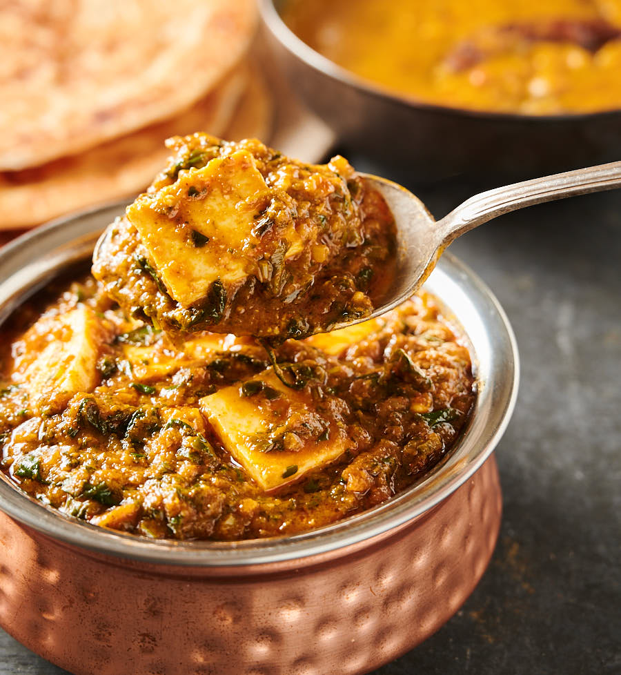 Close-up of a spoonful of palak paneer.